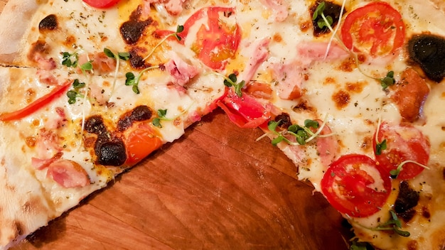 Pepperoni pizza on a wooden board with empty space, copy space. Pizza without three slices.