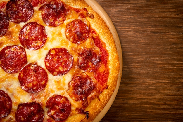 Foto pepperonipizza op houten dienblad