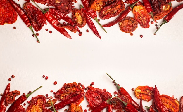 Foto peperoni e pomodori sfondo peperoncino essiccato e pomodori secchi rossi su un piatto bianco spezie e verdure cibo minimo piatto sfondo concetto foto di alta qualità