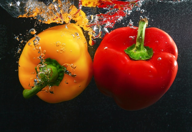 Peppers with splash isolated on black background