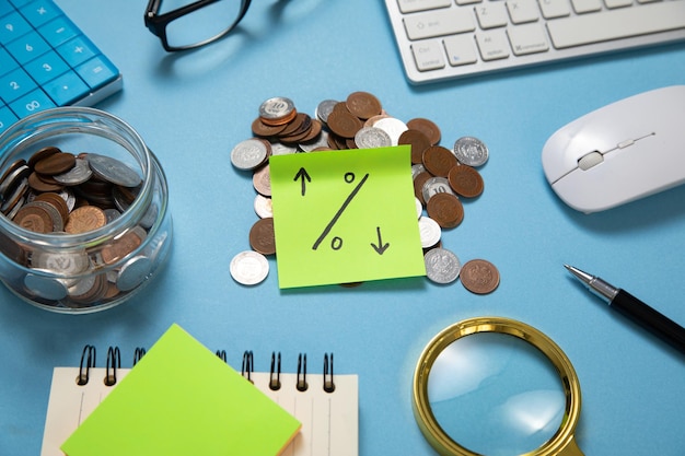 Percentage symbol on sticky note with a coins