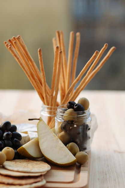 Peren en olijven op een houten bord