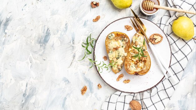 Peren gebakken met blauwe kaas, noten en honing. Franse keuken. Keto-dieet. Vegetarische lunch. banner, menu, receptplaats voor tekst, bovenaanzicht