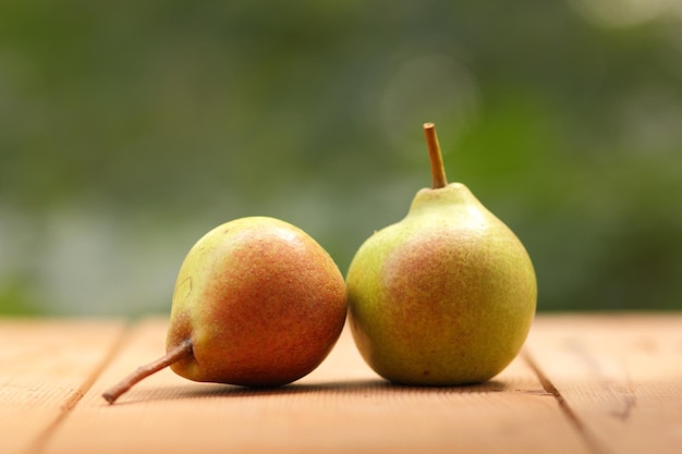 Peren op een houten tafel op een onscherpe achtergrond Hoop van rijpe sappige peren op bruine houten tafel close-up