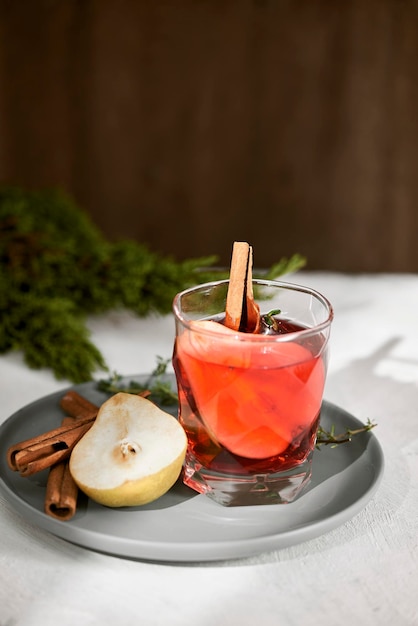 Perencocktail met rum-likeurpeerschijfjes en rozemarijn op witte tafel selectieve focus