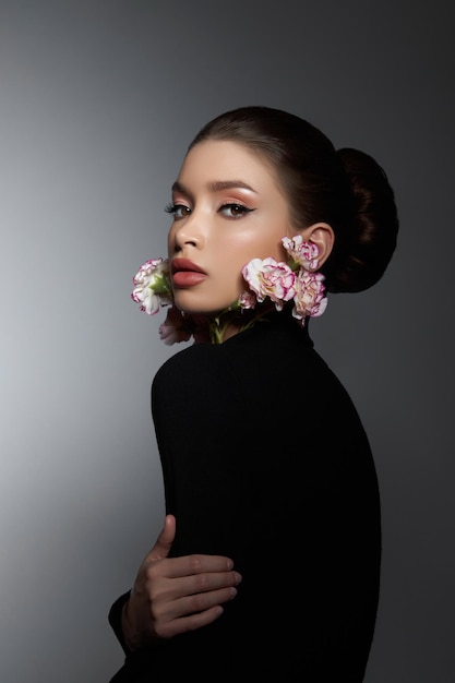 Perfect art woman in black turtleneck on a dark background Brunette long hair is pulled into a bun Evening makeup