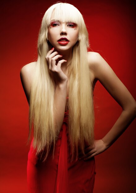 Perfect blond model in red dress over red .