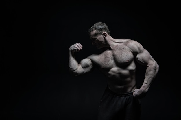 Perfect body. Man bodybuilder posing with tense muscles on black background. Bodybuilder achieved best shape for muscles. Ready for championship. Bodybuilder perfect muscular body, copy space.
