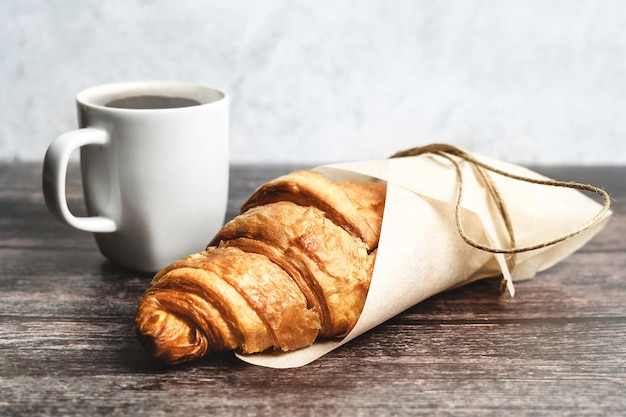 Perfect breakfast of croissant and coffee on wooden table Rustic style