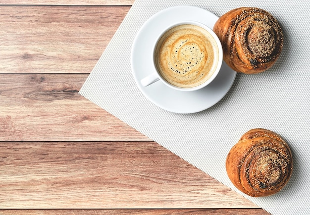 Perfect breakfast of homemade cinnamon buns and coffee on wooden table Rustic style