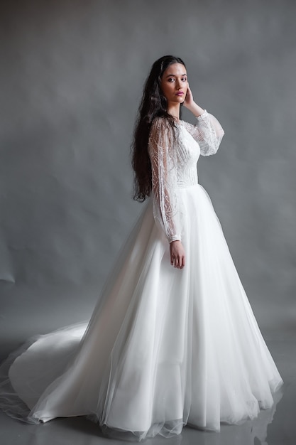 Perfect bride portrait of a girl in a long white dress Beautiful hair and clean delicate skin