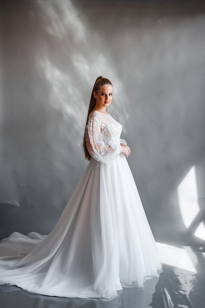 Perfect bride portrait of a girl in a long white dress beautiful hair and clean delicate skin