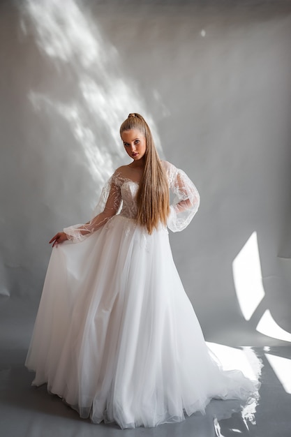 Perfect bride portrait of a girl in a long white dress beautiful hair and clean delicate skin