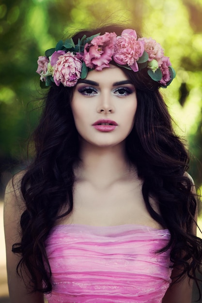 Perfect brunette model draagt roze jurk met bloemen buitenshuis