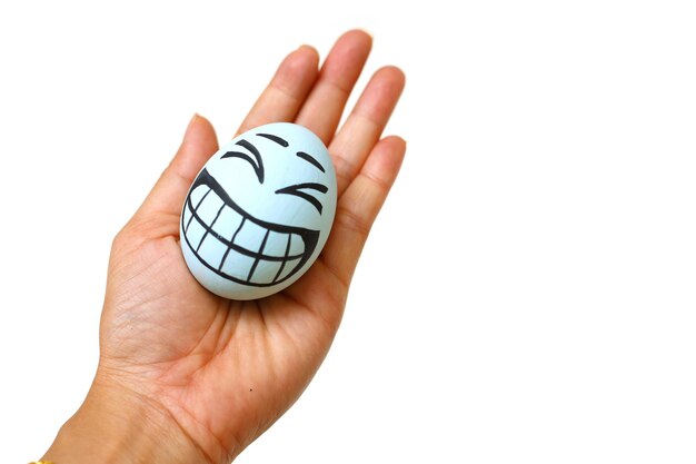 Perfect colorful handmade easter eggs with smile eggs in human hand isolated on a white background Easter day concepts Funny decoration Happy Easter