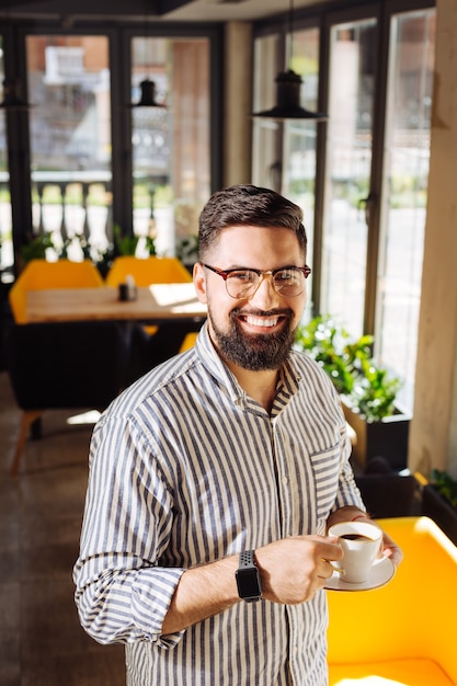 Perfect drink. happy nice man smiling to you while enjoying his morning espresso