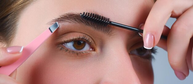 Perfect eyebrows close up of woman getting eyebrow makeup macro applying cosmetics on her eyebrow