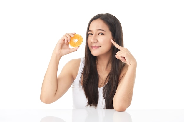 Perfect fresh skin portrait of the young Asian beautiful girl with orange slices in hand isolated on white background