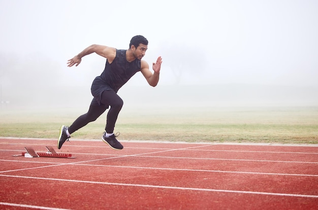 La vacanza perfetta. colpo integrale di un bel giovane atleta maschio che corre su una pista all'aperto.