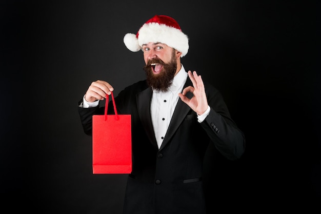 Perfect gift Happy businessman show OK sign Bearded man smile with gift in bag Shopping for Christmas gift Boxing day New year surprise Office party Gift from boss to empoyees copy space