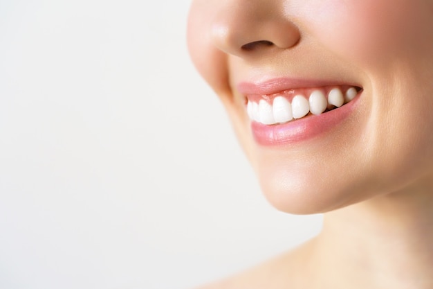 写真 若い女性の完璧な健康な歯の笑顔。歯のホワイトニング。歯科医院の患者。画像は、口腔ケア歯科、口腔病学を象徴しています。