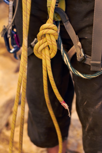 Il nodo perfetto ripresa ritagliata di un giovane scalatore in piedi che si aggiusta le imbracature