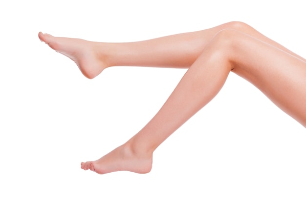 Perfect legs. Close-up of young woman with long legs isolated on white