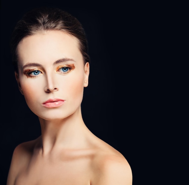 Совершенная модельная женщина на темном фоне. Здоровая кожа и макияж с золотыми тенями для век