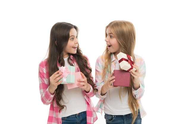 Perfect present for teen Birthday present Girls sisters or friends hold gift boxes Intriguing moment Small girls open holiday present Children excited cheerful faces hold presents Opening gifts