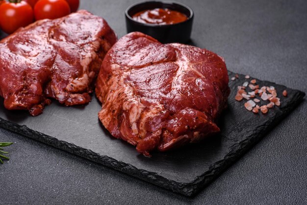 Perfect raw rib eye beef steak on black wooden background, close-up