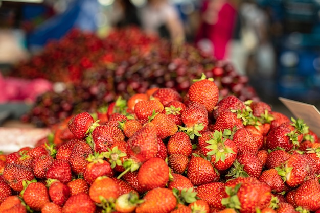 Le perfette fragole fresche mature rosse. la ciliegia sullo sfondo è sfocata