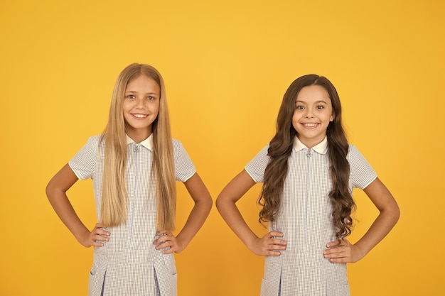 Studentesse perfette studentesse vintage stile semplice vestito studentesse allegre sfondo giallo bambine felice festa dei bambini pari protezione dei diritti civili e libertà dalla discriminazione