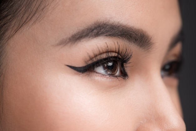 Идеальная форма бровей. Красивая макросъемка женского глаза с классическим макияжем подводки.