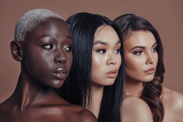 Perfect skin. Three attractive young women looking away 