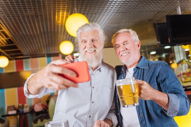 完璧な味。パブで休んでいる間ビールを楽しんでいる素敵なひげを生やした男