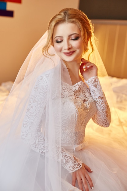 Perfect wedding day of woman bride, portrait of woman in white wedding dress in Bridal veil. Morning of the bride waiting for the groom and wedding ceremony