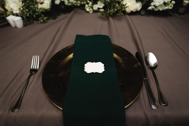 Идеальная сервировка свадебного стола для жениха и невесты. золотая посуда. тканевая салфетка лежит в золотой посуде. столовые приборы. свадебный декор