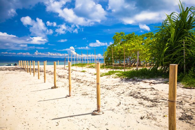 Perfect white beach with turquoise water and a small fence on desert island