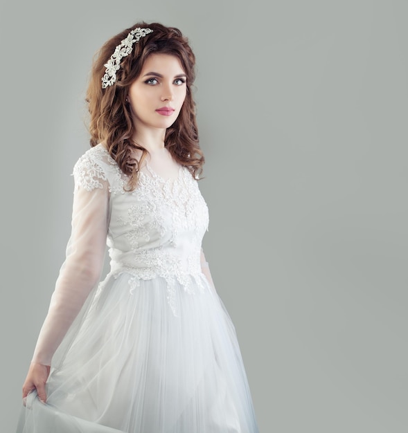 コピースペースで背景に白いウェディングドレスの完璧な若い花嫁の女性