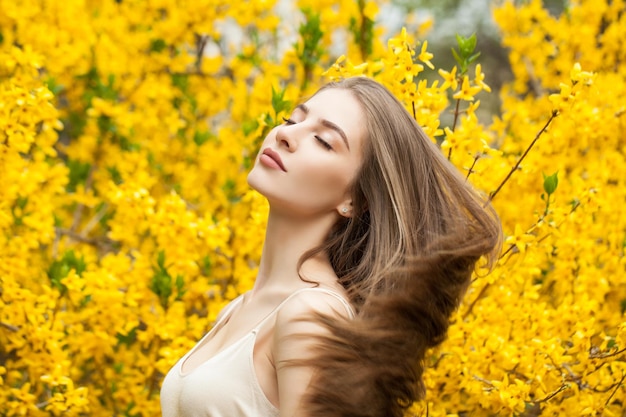 Perfect young woman with healthy hairstyle on floral background