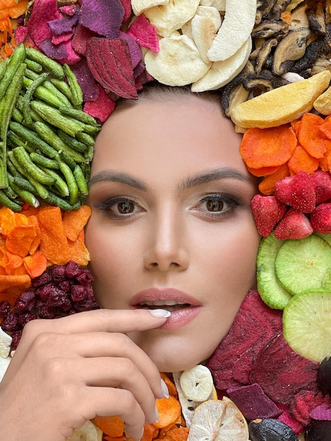Foto perfecte gezonde vrouw op kleurrijke levendige biologische fruit en groenten chips achtergrond gezonde voeding en dieet concept