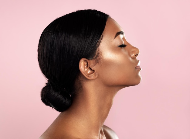 Perfection in profile Studio shot of a beautiful young woman posing with her eyes closed against a pink background