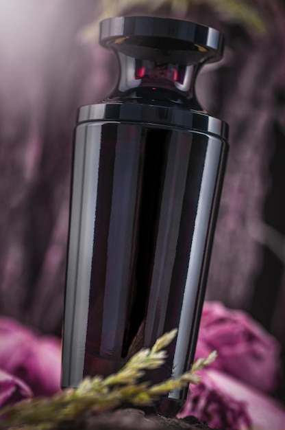 古い木の樹皮と乾燥したバラを背景にした香水瓶