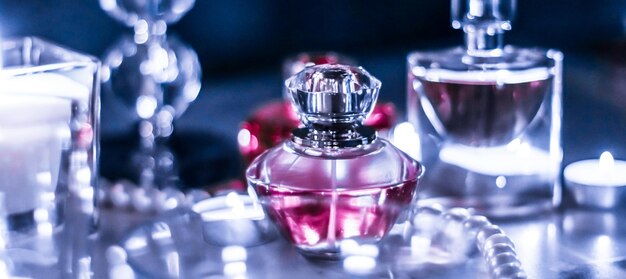 Perfume bottle and vintage fragrance on glamour vanity table at night pearls jewellery and eau de parfum as holiday gift luxury beauty brand present