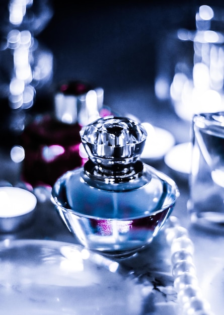 夜の魅力的な化粧台に香水瓶とビンテージ フレグランスパール ジュエリーとオード パルファムをホリデー ギフトの高級ビューティー ブランド プレゼントとして
