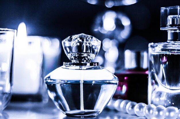 Bottiglia di profumo e fragranze vintage sul tavolo da toeletta glamour di notte perle gioielli e eau de parfum come regalo di vacanza marchio di bellezza di lusso presente