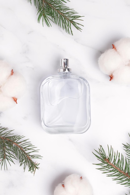 Perfume bottle with fir tree branch cotton flowers New year Christmas perfume gift Winter holiday celebration perfume composition Idea for gift with love