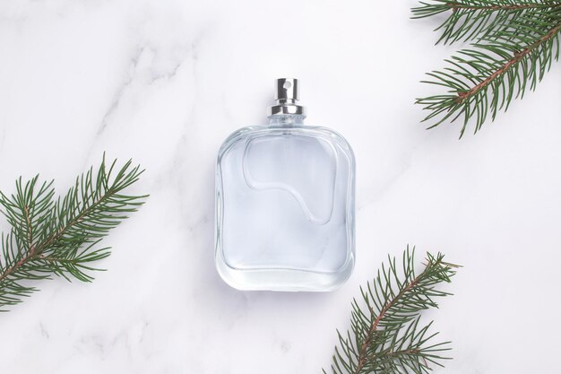 Foto bottiglia di profumo con ramo di abete regalo di profumo di natale di capodanno composizione di profumo per celebrazione delle vacanze invernali idea per un regalo con amore