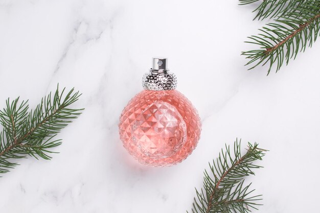 Perfume bottle with fir tree branch New year Christmas perfume gift Winter holiday