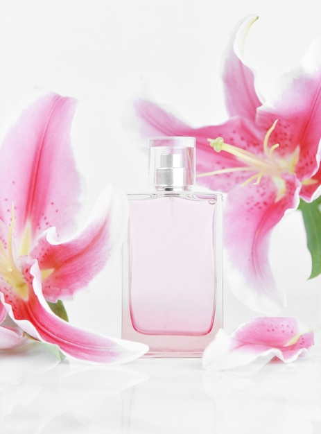 Foto bottiglia di profumo con fiori di giglio rosa